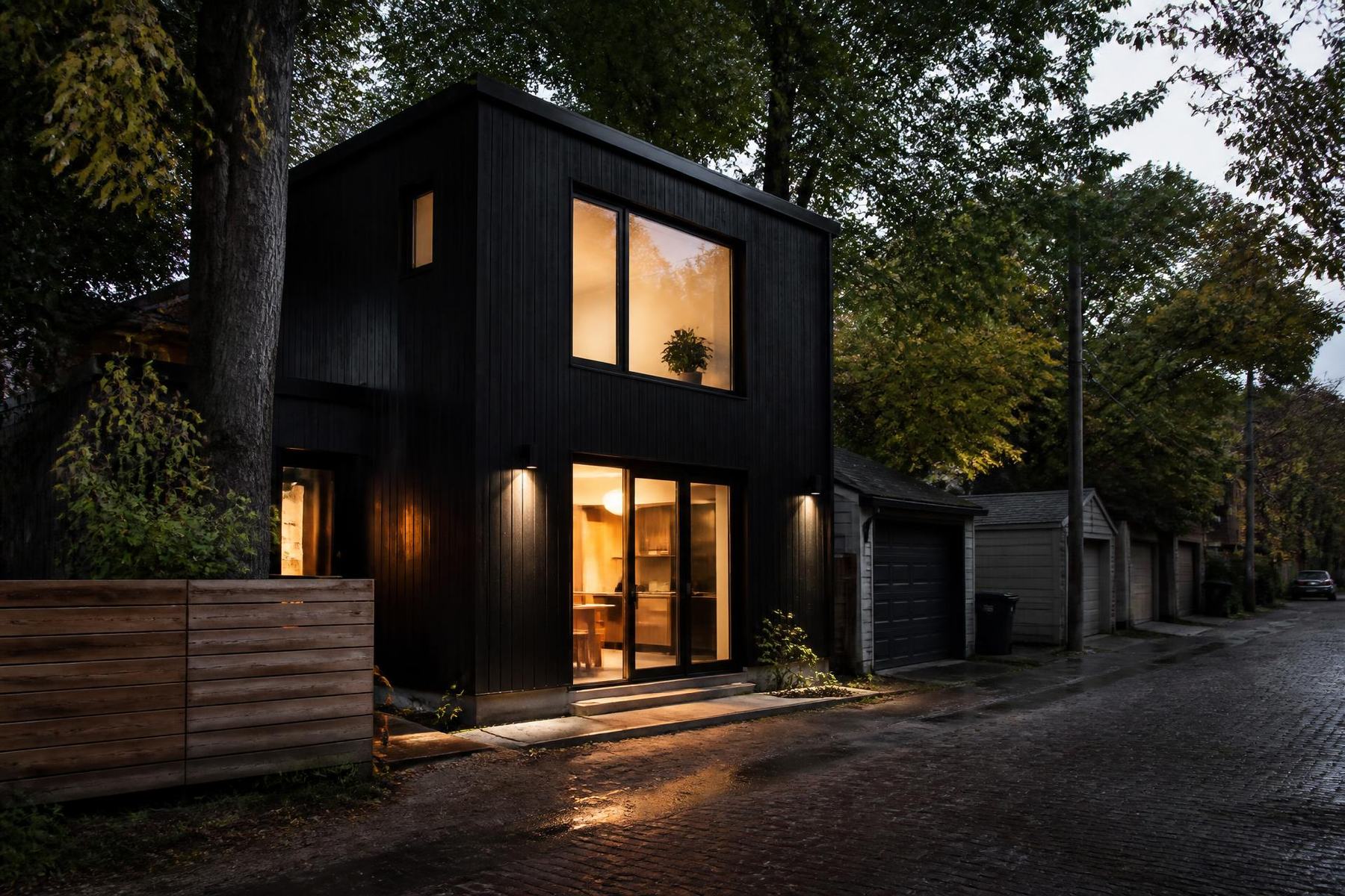 Modern black-clad laneway home in a Toronto laneway at dusk